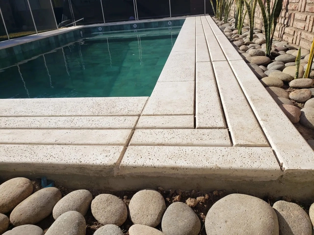 Pileta protegida con baldosones y piedras tamboreadas